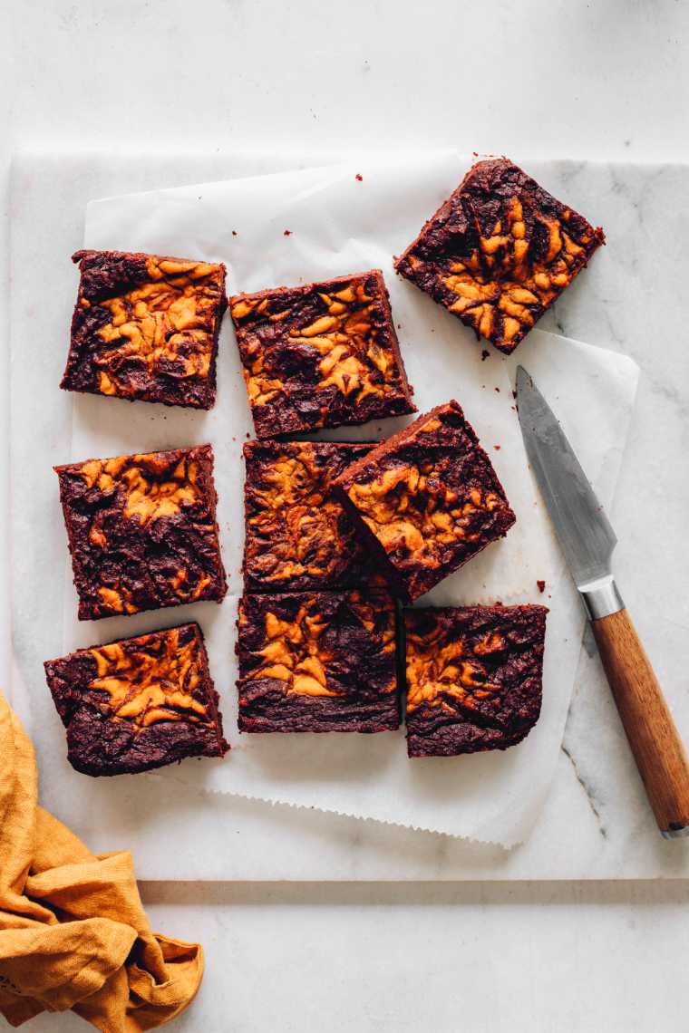 cutting board with 9 freshly baked pumpkin brownies and a knife