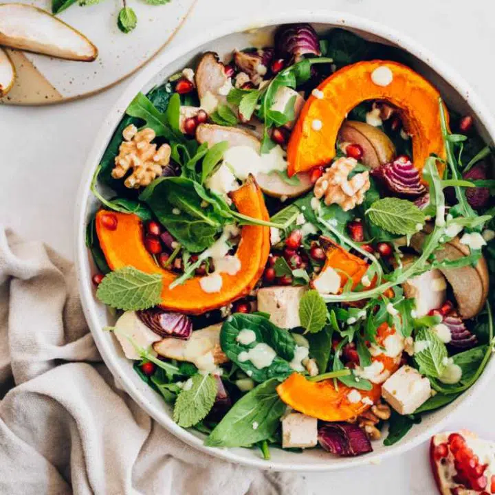 large bowl with pumpkin, spinach and feta salad next to a towel