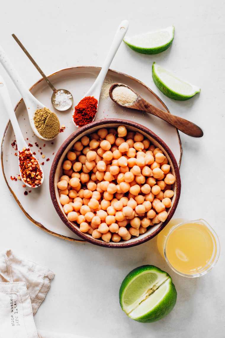 table with cooked chickpeas, lime and different spices