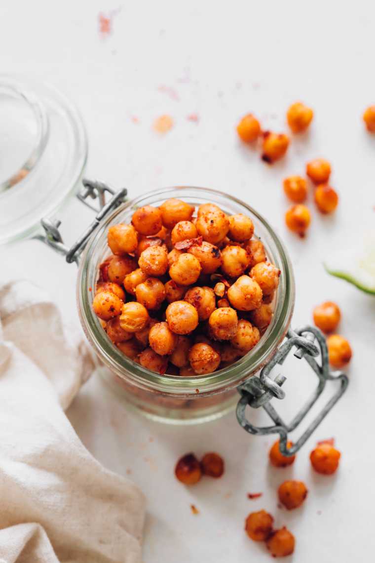 glass jar on a table filled with oil-free roasted chickpeas
