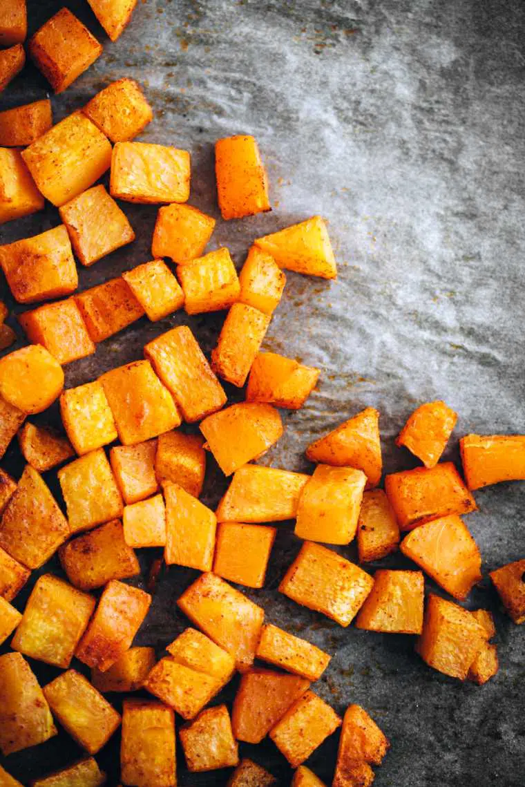 stone table with bright orange cubed and roasted butternut squash