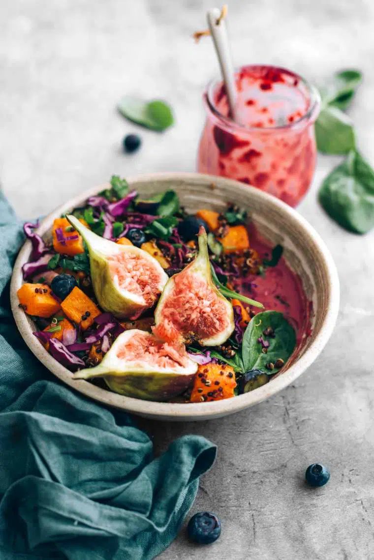 close up of a bowl with colorful vegan spinach fig salad with roast pumpkin and blueberry dressing