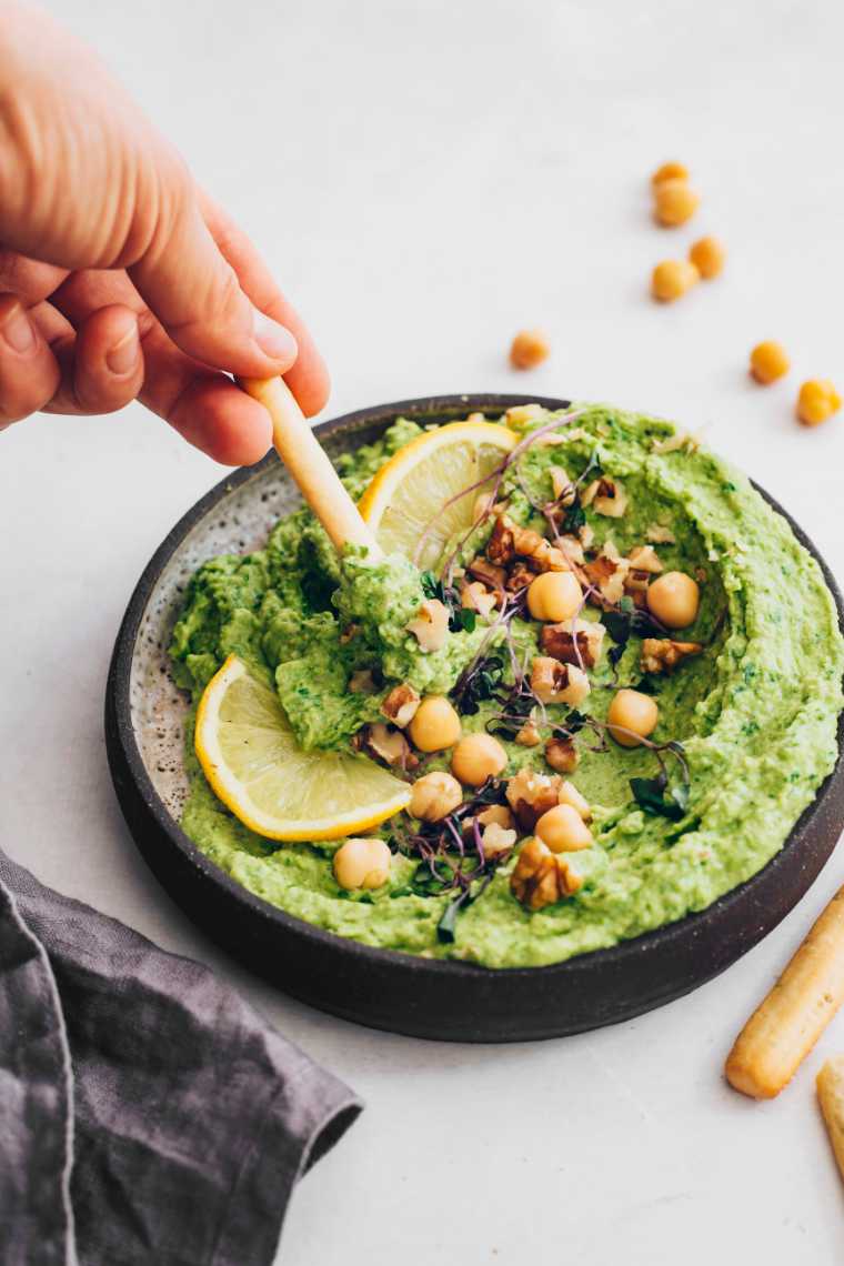 small bowl with homemade green goddess hummus that's used as a breadstick dip