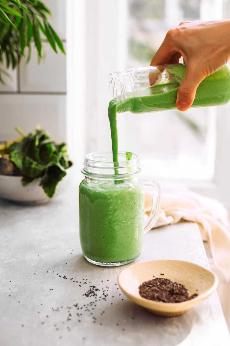 pouring creamy vegan green broccoli smoothie in a glass
