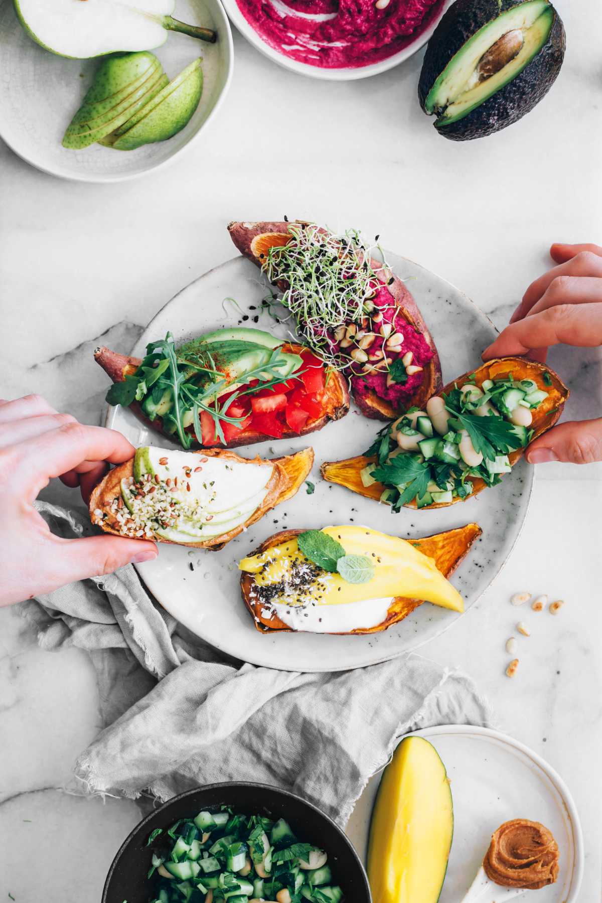 two hands reaching for colorful sweet potato toasts