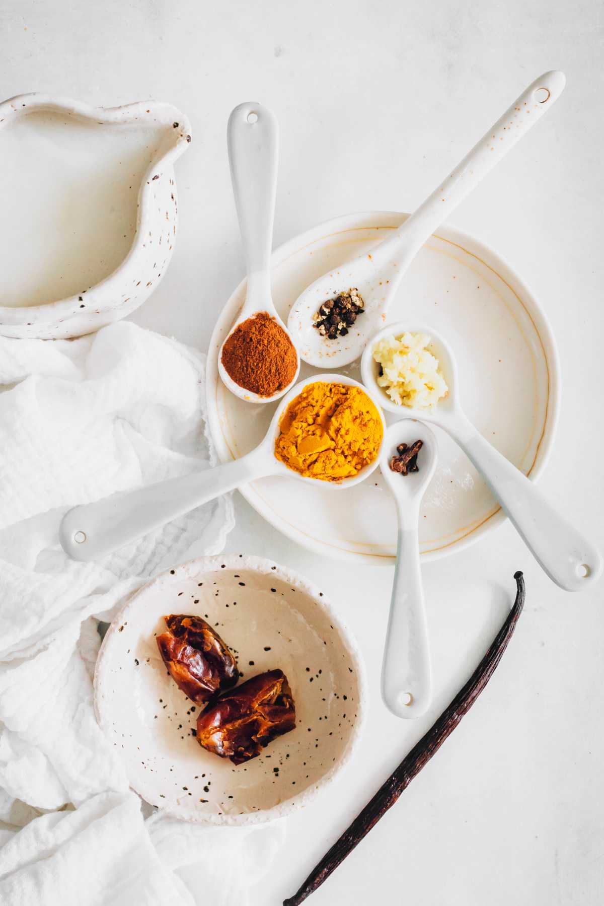 spices and vegan milk, dates and towel on table