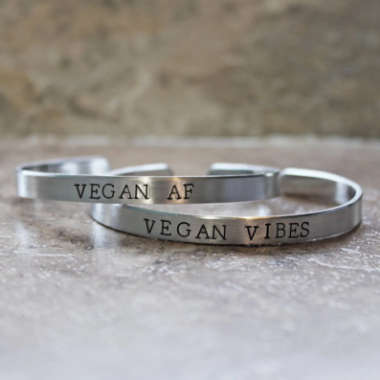 Two silver bracelets with hand-stamped letters Vegan AF and Vegan Vibes
