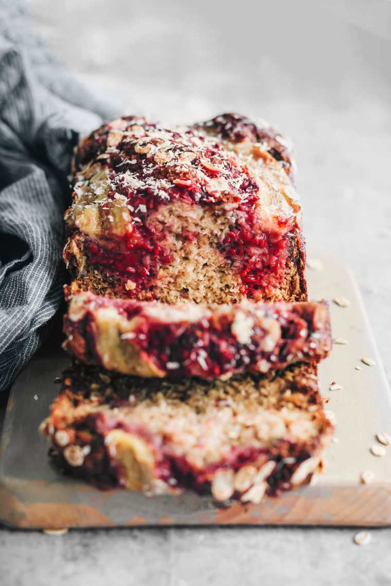 Slices of Vegan Banana Bread with raspberries on cutting board