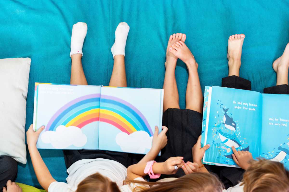 several kids reading vegan children's books on a sofa