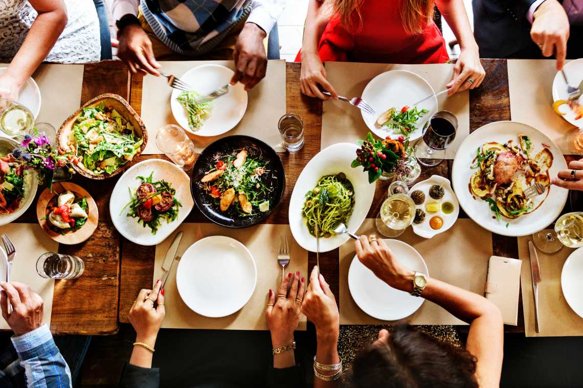 group of people sitting around a table and enjoying vegan-friendly cuisines