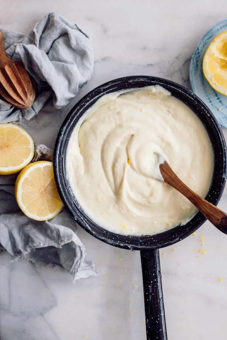 black pan filled with yellow creamy vegan custard on a white table