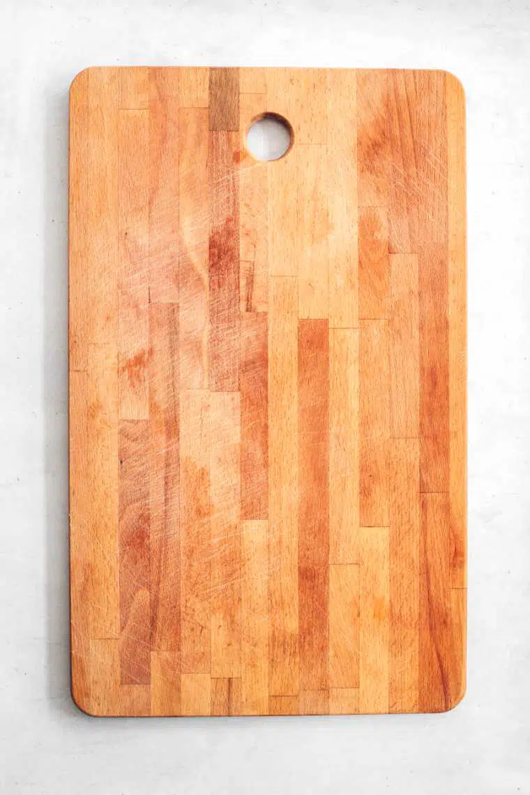 empty wooden cutting board on white surface