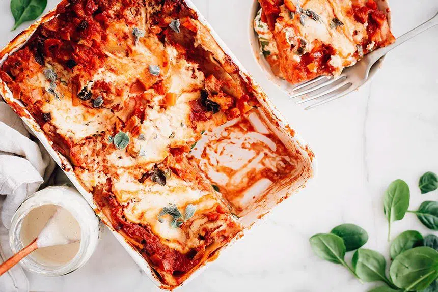 top view of baked vegan lasagna with one piece cut out on put in a bowl
