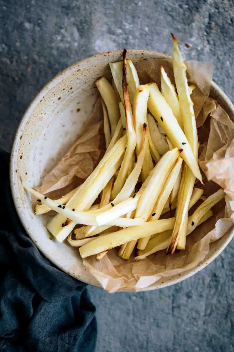 white speckled bowl with two handfuls of homemade oil-free parsnip fries
