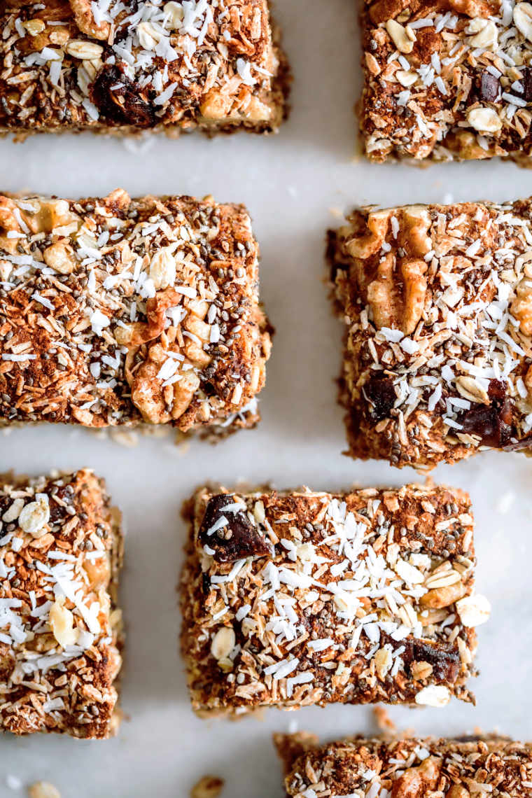top view of six vegan oat squared topped with coconut flakes