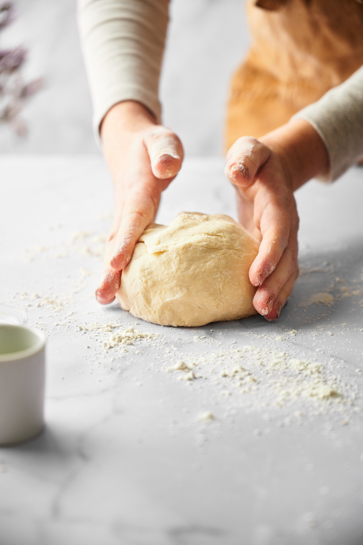 woman forming vegan pizza dough on a table