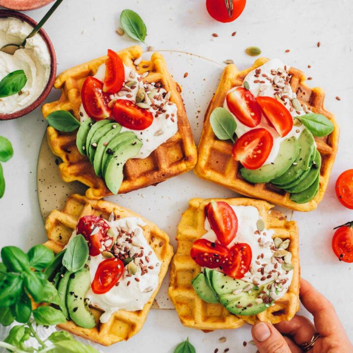 savory vegan waffles topped with basil, ricotta, tomatoes, and avocado