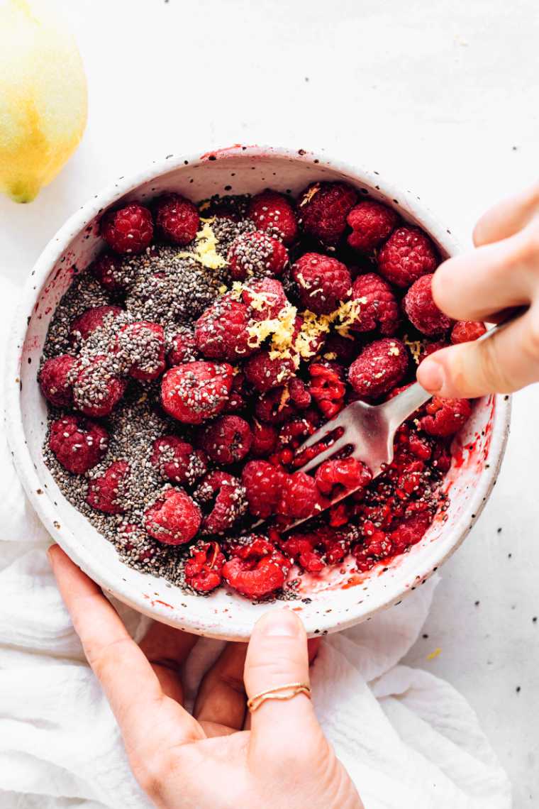 mixing berries with chia seeds and lemon using a fork