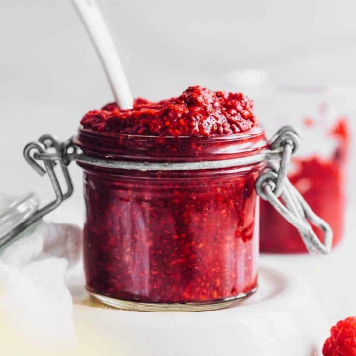 glass jar on a table with homemade vegan berry chia jam