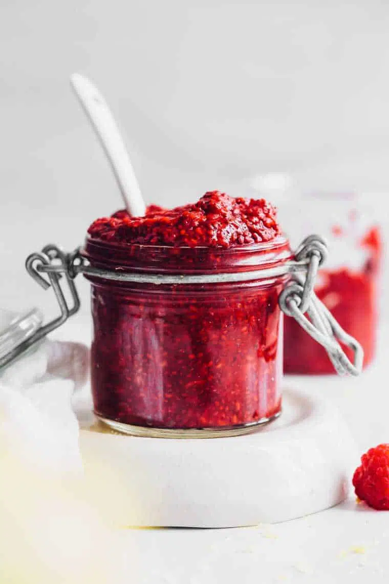 glass jar on a table with homemade vegan berry chia jam