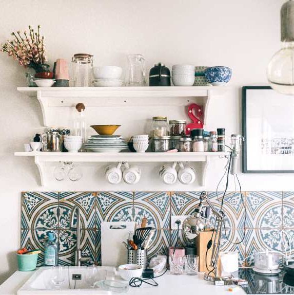 vintage kitchen with flowers, colorful tiles, sink and different kitchen tools