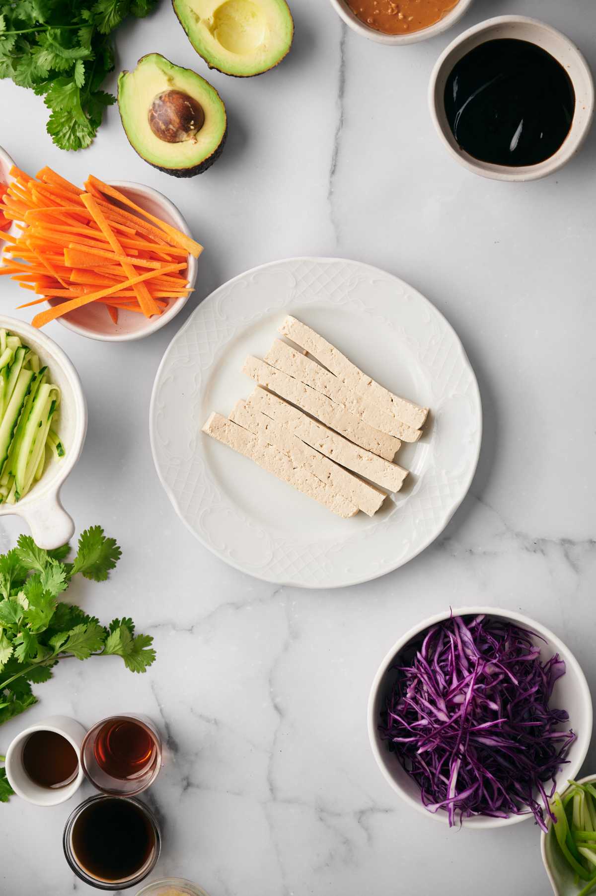 sliced tofu on a plate next to fresh veggies