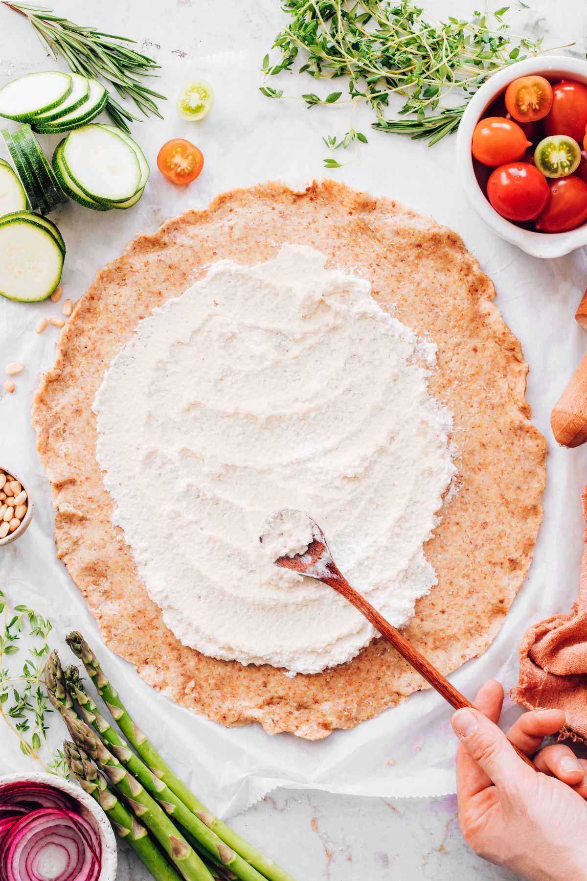 adding ricotta on galette crust with a spoon
