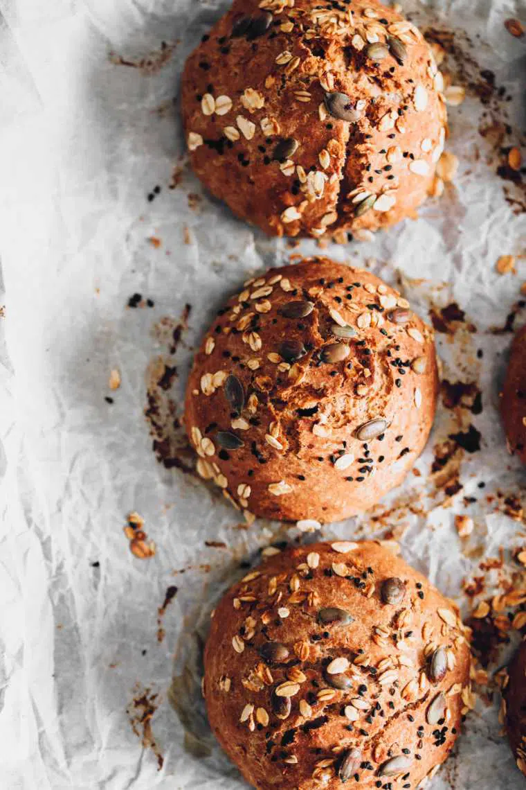 freshly baked whole wheat rolls topped with oats and seeds
