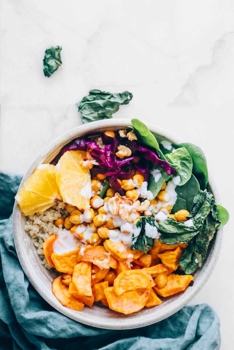 top view of a colorful winter Buddha bowl made from roasted veggies, chickpeas, quinoa and fresh greens