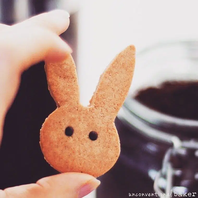 hand holding a vegan cinnamon bunny cookie with eyes as a vegan Easter dessert treat