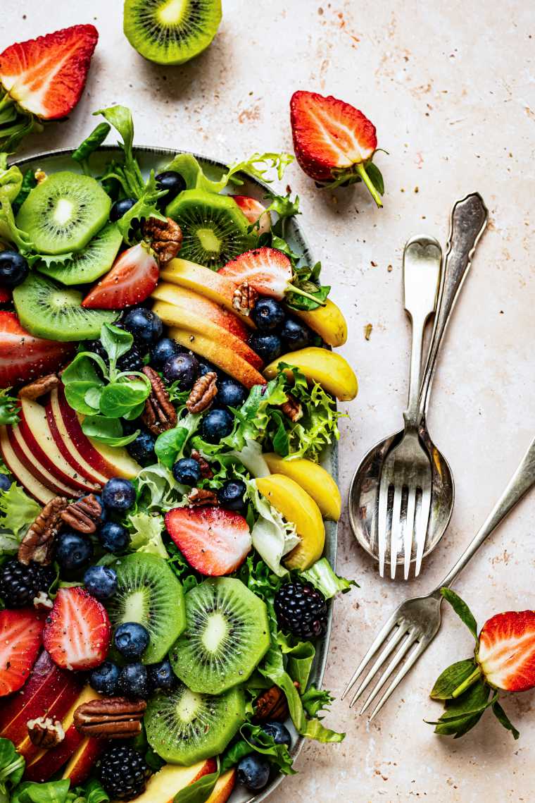 close up of a Healthy fruit salad with vegetables and pecans on a plate