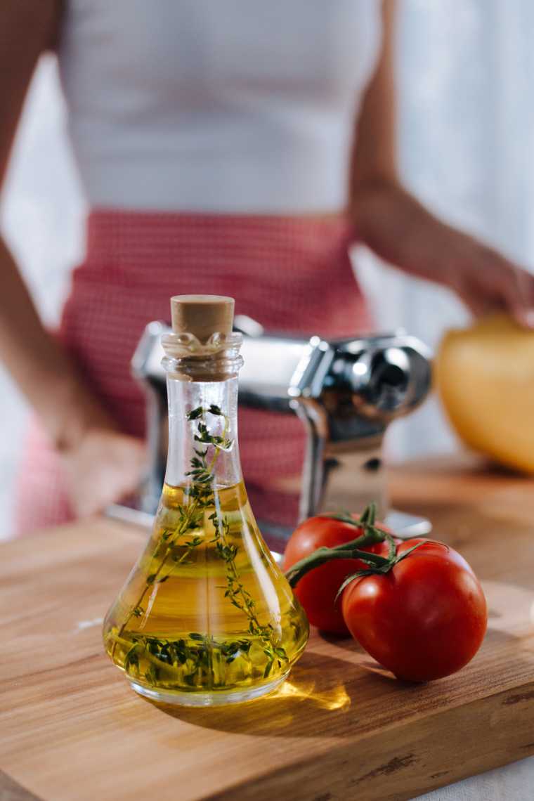 bottle of olive oil and tomatoes on a cutting board