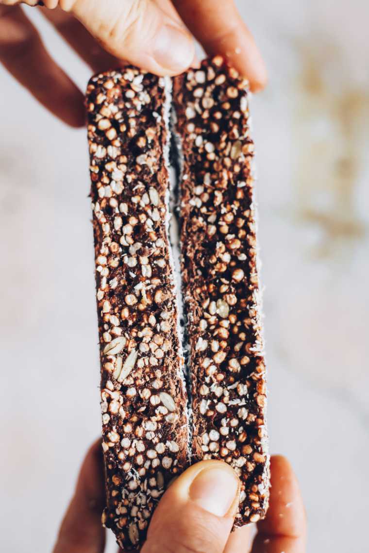 Closeup of hands holding two puffed quinoa bars