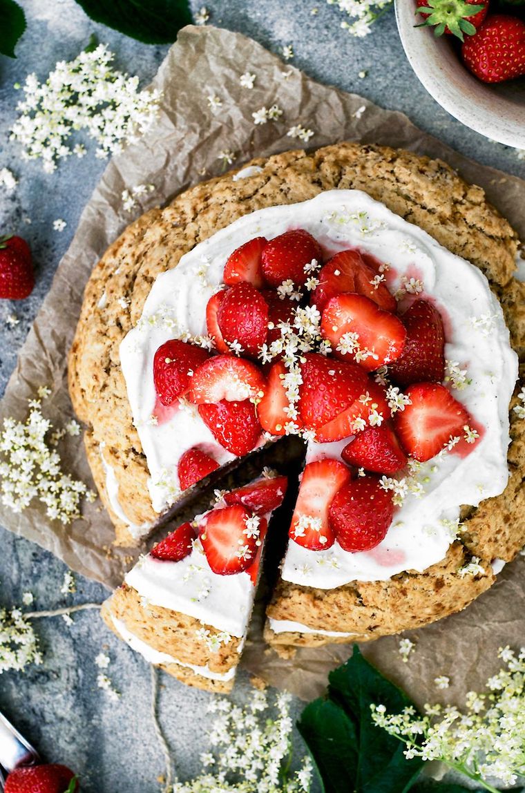 layered vegan strawberry cream scone cake decorated with elderflower